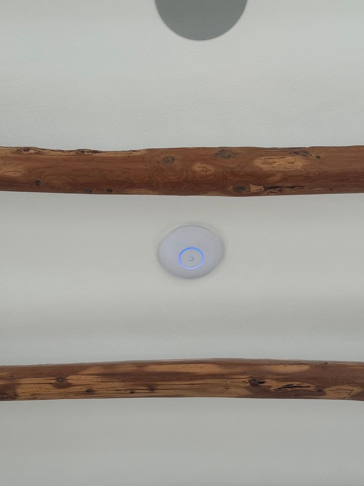 UniFi ceiling access point - between Bermuda's classic exposed wood beams